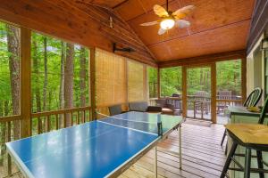 a screened in porch with a ping pong table at Artisan Hideaway in Helen