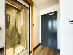a bathroom with a shower and a black door at Bohemian Chic Retreat in Liverpool