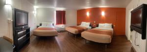 a hotel room with two beds and a flat screen tv at Regal 8 Inn & Suites in Lincoln