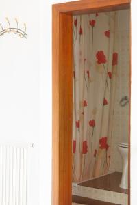 um armário de vidro com uma cortina com flores vermelhas em CHECK in ECK MOTEL em Sankt Kanzian