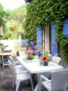 プリヴァにあるMoulin De Cornevis Bed and Breakfastの白い椅子と花のテーブル