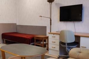 a living room with a desk and a bed and a table at Cozy easy-to-stay 2room apartment 1km from Rauma centre in Rauma