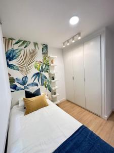sypialnia z dużym białym łóżkiem z niebieskim dywanem w obiekcie Holidays2Malaga Lebrija 3 bedroom & Terrace & Parking & Smart TV w Maladze