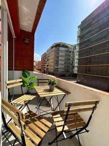 een balkon met tafels en stoelen in een gebouw bij Holidays2Malaga Lebrija 3 bedroom & Terrace & Parking & Smart TV in Málaga