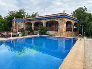 una gran piscina azul frente a un edificio en Villa Rosi en Albacete