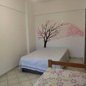 1 dormitorio con un árbol pintado en la pared en Ótimo Apartamento Frente ao Mar em Mongaguá, en Mongaguá