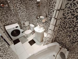 a bathroom with a toilet and a sink and a tub at Centrally located Studio apartment in Rīga +26 photos