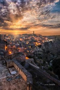 a view of a city at sunset with tables and chairs at Torretta ai Sassi in Matera