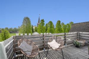 dos sillas sentadas en una terraza con una valla en Nummertje50, en Wommels