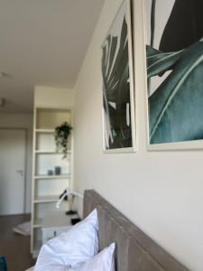 - un salon avec un canapé et deux photos sur le mur dans l'établissement Wanderlust Petrisberg - Studio 53, à Trèves
