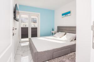 a bedroom with a bed and a blue wall at Apartmani Podoreški in Vir