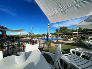 un patio con mesa, sillas y piscina en Villa Rosi en Albacete