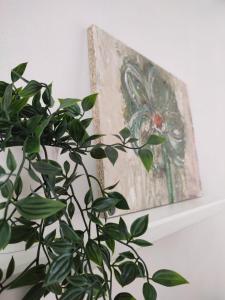 een plant naast een schilderij aan een muur bij Piso Sol in Laxe