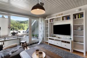 ein Wohnzimmer mit einem TV und einem großen Fenster in der Unterkunft Ferienwohnung Schwarzwald Engel in Bad Peterstal-Griesbach