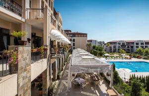 un balcón de un hotel con piscina y sombrillas en Sea Star Sozopol en Sozopol
