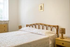 1 dormitorio con 1 cama con edredón blanco en Villetta Caterina near the beach, en Ostuni
