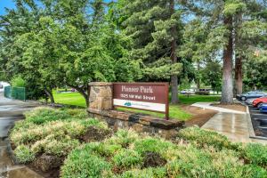 Pioneer Park Rentals Downtown Bend في بيند: علامة لحديقة الحارس مع الأشجار في الخلفية