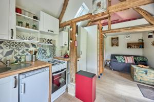 eine Küche und ein Wohnzimmer mit einem roten Kühlschrank in der Unterkunft Le chouette insolite in Cresseveuille