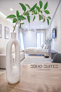 巴爾的住宿－Soho Suites，客厅的一张桌子上的一个白色花瓶
