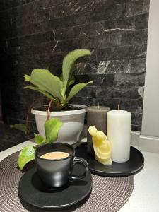 uma mesa com uma chávena de café e velas em Villa Residence em Kvariati