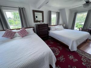 a bedroom with two beds and a mirror and windows at The Reserve Retreat in Sarasota