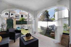 een woonkamer met een boog en een patio bij Apartaclub la Barrosa in Chiclana de la Frontera