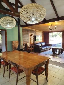 sala de estar con mesa de madera y sillas en Varswaterkloof Houthuis en Paarl
