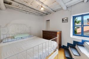 ein Schlafzimmer mit einem weißen Bett und einem Fenster in der Unterkunft Villa Luisa in Vezzi Portio