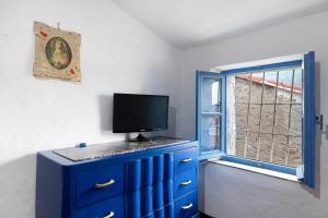 eine blaue Kommode mit einem Fernseher darüber in der Unterkunft Villa Luisa in Vezzi Portio