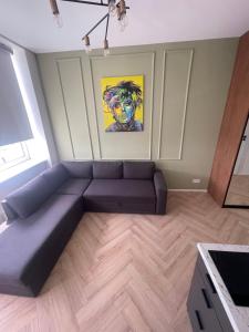 uma sala de estar com um sofá e um quadro em Airport Apartment 14 Self Check-In Free parking em Vilnius