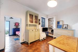 Zimmer mit einer Küche mit einem Schreibtisch und einem Tisch in der Unterkunft Villa Luisa in Vezzi Portio