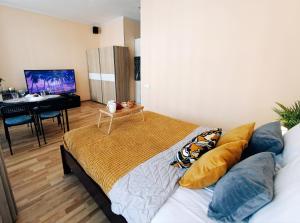 a bedroom with a bed with pillows and a table at Centrally located Studio Apartment in Riga