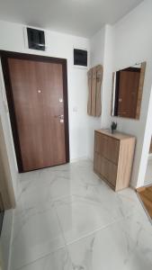 sala de estar con puerta de madera y suelo de baldosa en Sunny Guest House en Skopie