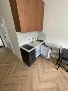 a kitchen with a sink and a wooden floor at Airport Apartment 14 Self Check-In Free parking in Vilnius