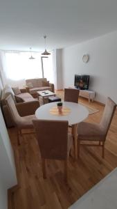 uma sala de estar com mesa e cadeiras em Sunny Guest House em Skopje