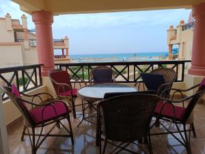 a balcony with tables and chairs and a view of the ocean at lazorde Bay in El Alamein