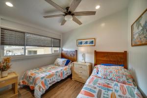 a bedroom with two beds and a ceiling fan at Updated Poipu Home Large Deck with Scenic View in Koloa