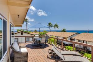 科洛阿的住宿－Updated Poipu Home Large Deck with Scenic View，房屋内带椅子和遮阳伞的甲板