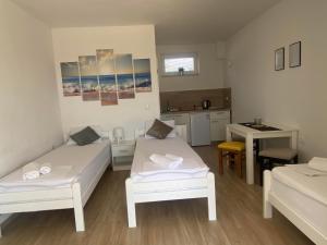 une petite chambre avec deux lits et une table dans l'établissement Studio apartmani Alex, à Novalja
