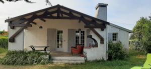 una pequeña casa blanca con una mesa delante en Jolie villa avec jardin à proximité de la plage, en La Brée-les-Bains