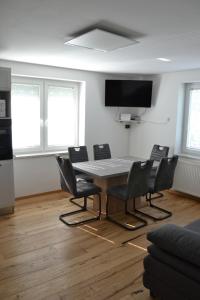 LučeにあるApartma ob potokuのテーブルと椅子、薄型テレビが備わる客室です。