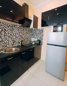 a kitchen with a white refrigerator and a sink at Centrally located Studio Apartment in Riga