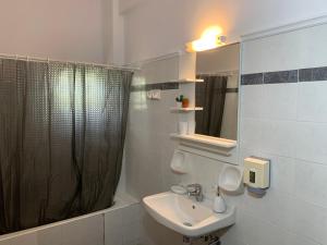 a bathroom with a sink and a shower curtain at Katerinas Inn Apartments in Keri