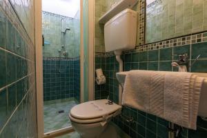 a green tiled bathroom with a toilet and a shower at Hotel River fronte mare con piscina in Rimini