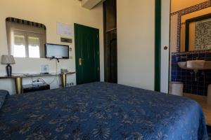 a bedroom with a blue bed and a sink at Hotel River fronte mare con piscina in Rimini