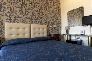 una camera da letto con un letto con piumone blu e carta da parati di Hotel River fronte mare con piscina a Rimini