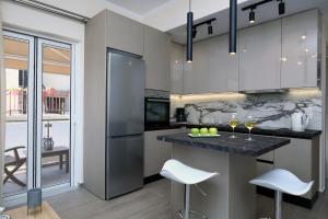 eine Küche mit Küchengeräten aus Edelstahl und weißen Hockern in der Unterkunft Kallithea Guesthouse in Nydri