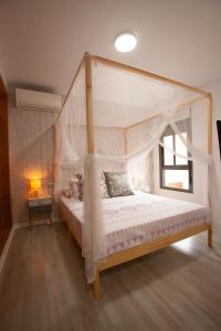 a bedroom with a canopy bed and a window at Suites Beach Nature by Alterhome in Vélez-Málaga