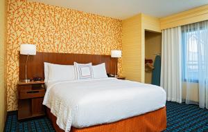 Fairfield Inn and Suites by Marriott Rochester West/Greece في روتشستر: غرفه فندقيه بسرير ونافذه