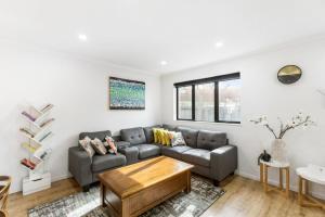 a living room with a couch and a table at Modern 5BR in Mangere - 6 mins from the Airport in Auckland